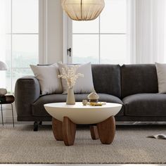 a living room with a gray couch and white coffee table