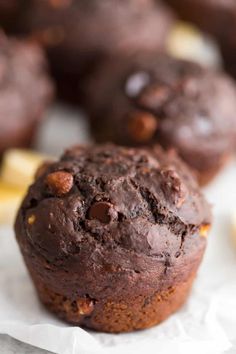 chocolate muffins sitting on top of white paper