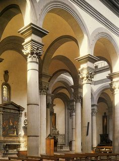 the interior of an old church with pews and arches on either side of the alter