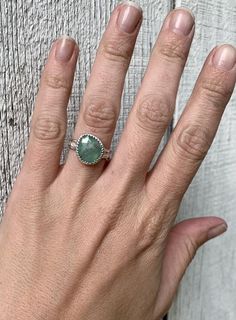 A stunning light green raw sapphire has been set in sterling silver with a handmade ring band from a uniquely patterned sterling silver rounded edge wire. This sapphire stone is just breathtaking with its light green hue and gray stripe running through the center. The faceted cut of the sapphire helps the gemstone catch the light and truly sparkle. The stone sits in a serrated setting. It is 13mm x 12mm at the widest points in size.Size 7, cannot be sized up or down. Pink Stone Engagement Rings, Raw Sapphire, Birthstone Engagement Rings, September Birthstone Ring, Pink Stone Rings, Pink Engagement Ring, September Birthstone Rings, Green And Gray, Ring Sapphire