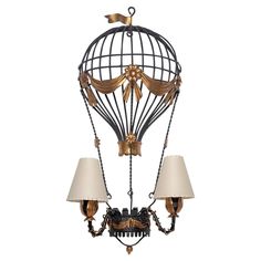 a wall mounted light with two lamps on it's sides and a bird cage design