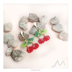 four pieces of beaded earrings sitting on top of rocks