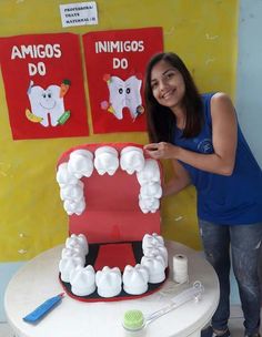 a woman standing in front of a fake toothpaste teethhelf on a table