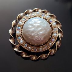 Lovely Vintage Ornate Brooch with Faux Pearls and Aurora Borealis Crystals.  Elegant and classic design. A beautiful addition to office wear. For new arrivals check out the store's Instagram account https://www.instagram.com/helensjewellerybox/ All jewelry is photographed in natural light and may have light scratches due to age and wear. Thank you for looking and if you have any questions please don't hesitate to ask :) Elegant Pearl Brooches For Formal Occasions, Vintage Gold Pearl Brooches, Vintage Pearl Gold Brooches, Elegant Evening Pearl Brooches, Elegant Pearl Brooches For Evening, Elegant Round Brooches For Vintage Events, White Pearl Brooches For Formal Occasions, Formal Gold Pearl Brooches, Formal White Pearl Brooches