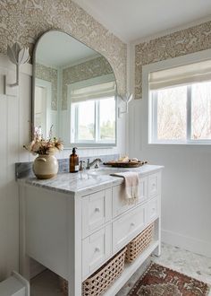 a bathroom with a sink, mirror and rug on the floor in front of it