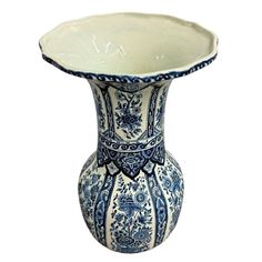 a blue and white vase with an ornate design on the bottom, sitting in front of a white background