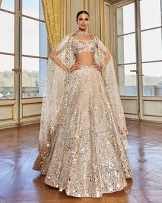 This lehenga set features intricate embroidery in rose gold thread and mirror. It is paired with an embroidered blouse and an all over jaal dupatta.From Seema Gujral's Love Notes From Paris Collection DELIVERY TIMEPlease allow 8-12 weeks for your outfit to arrive. FABRIC DETAILSNet Professional cleaning only. Seema Gujral, Baju Kahwin, Gold Lehenga, Mirror Work Lehenga, Work Lehenga, Rose Gold Mirror, Wedding Lehenga, Lehenga Designs, Gold Thread