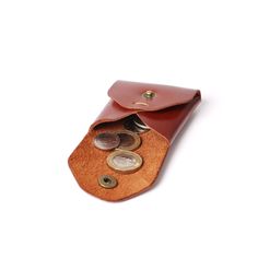 "Handmade Genuine Leather Coin Holder and Pouch Leather Coin Case. This little helper will keep your loose changes organised. It's small enough to slip in your pocket and drop in the side pocket of your bag. Bulk order discounts - Available! We offer discount on orders with 5 or more products. MAIN FEATURES * Made from full grain cow leather * Durable and gets beautiful over time * Dimensions: 6 cm x 6 cm x 1 cm (2.4\" x 2.4\" x 0.4\") * Snap button closure to keep the coins secure FREE PERSONALISATION We offer a free of charge personalisation service; initials or a name (up to 6 characters) engraved in upper / lowercase letters. Please send us your initials/name on the \"Note to JoyToken\" section on your checkout." Brown Coin Purse With Coin Pocket For Travel, Brown Pouch With Coin Pocket As Gift, Coin Purse With Interior Card Slots, Brown Coin Purse With Coin Pocket For Everyday Use, Brown Pouch With Coin Pocket For Daily Use, Brown Pouch With Card Slots For Personal Use, Everyday Brown Pouch With Coin Pocket, Daily Use Brown Pouch With Coin Pocket, Bifold Coin Purse With Interior Key Chain Holder