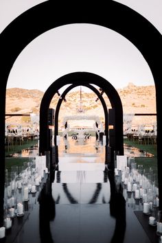 an outdoor ceremony with white candles and black arches