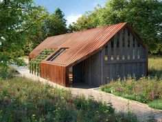 a small wooden building sitting on top of a lush green field next to trees and flowers