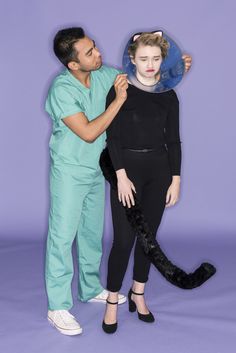 a man and woman are dressed up as cats for the halloween costume contest in front of a purple background