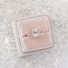 an engagement ring sits in a velvet box