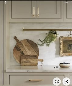 a wooden cutting board sitting on top of a kitchen counter next to a framed photo