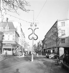 an old black and white photo of a street sign with the letter s on it