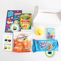 an assortment of children's snacks and candy on a white table with a rubber ducky toy