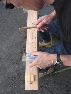 a man is measuring wood with a ruler