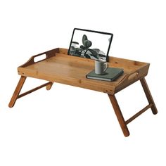 a wooden tray with a laptop on it and a cup sitting on top of it