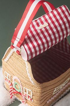 a red and white checkered bag sitting on top of a table next to a stuffed animal