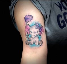 an elephant with a heart balloon tattoo on the arm