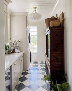 a kitchen with white cabinets and black and white checkered flooring on the walls