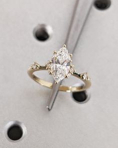 a diamond ring sitting on top of a piece of metal