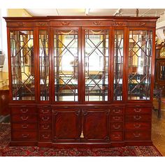 a large wooden china cabinet sitting on top of a rug