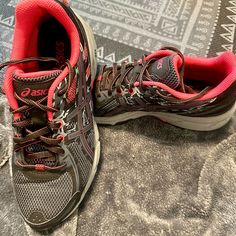 a pair of running shoes sitting on top of a carpet