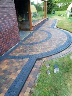 a brick patio with steps leading up to the back door and an open glass window