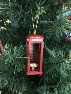 an ornament hanging from a christmas tree in the shape of a phone booth