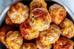 a bowl filled with cheesy meatballs covered in cheese