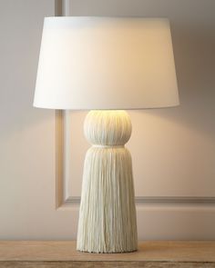 a white lamp sitting on top of a wooden table