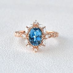 a blue and white diamond ring sitting on top of a white surface with diamonds around it