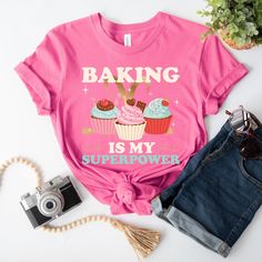 "Unleash your baking prowess with this charming \"Baking is My Superpower\" Cupcake Graphic T-Shirt! Featuring a vibrant cupcake graphic and a bold empowering phrase, this soft cotton tee is a must-have for baking enthusiasts. Perfect for casual outings, baking sessions, or as a thoughtful gift, this t-shirt combines style and passion. Order yours today and embrace the power of baking! Production Time:  2-5 business days (usually 2-3 days) Materials: ~Bella and Canvas 3001 Unisex Tshirt  ~100% A Cupcake Graphic, Baker Gifts, Cupcake Shirt, Chef Shirt, Cupcake Queen, Baker Shirts, Chef Shirts, Cupcake Gift, Nunchucks