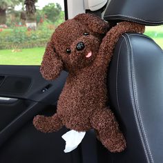 a brown stuffed animal sitting in the back seat of a car