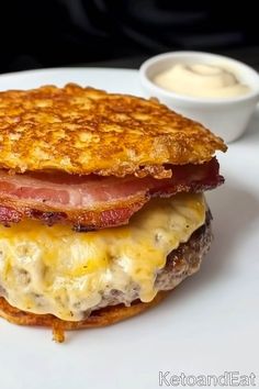 a close up of a sandwich on a plate near a bowl of mayonnaise