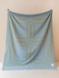 a blue and beige blanket with fringes on it