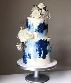 a blue and white cake with flowers on top