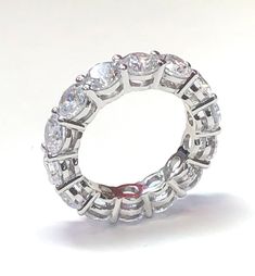 Our eternity band is a showstopper. Featuring round brilliant cut prong set cubic zirconia stones. Wear the band solo or stack with other rings, either way the look is luxurious. See our other bands for stacking. half sizes available. The ring on the right is also available. Item Details: TCW: 4.8 Style: Eternity Band Alternate Style: Cocktail Gender: Women's Stone Color: Clear Stone Cut: Round Stone Size: 4.5 mm Stone Material: Cubic Zirconia Stone Setting: Prong Ring Dimensions: 22 mm x 4.5 mm Lab Grown Diamond Eternity Band For Promise, Channel Set Cubic Zirconia Diamond Ring, Round Lab Grown Diamond Eternity Band Promise Ring, White Eternity Band With Vs Clarity, Lab Grown Diamond Eternity Band With Prong Setting, Dazzling Lab-grown Diamond Eternity Band, White Vs Clarity Round Eternity Band, Diamond Eternity Promise Ring With Round Cut, Round Cubic Zirconia Ring Channel Set