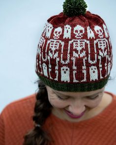 a woman wearing a red and white knitted hat while looking at her cell phone