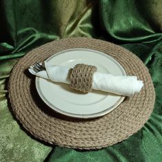 a white plate topped with a fork and napkin on top of a green table cloth