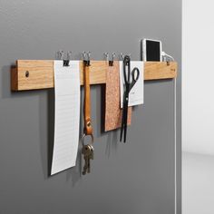 there are several keys hanging on the wall with notepads and clipboards attached to it