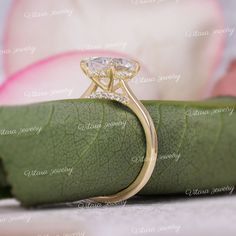 a close up of a diamond ring on top of a leaf