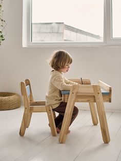 a young child sitting at a wooden table