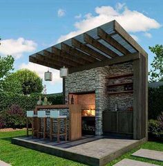 an outdoor kitchen with stone walls and grilling area in the middle of a lawn