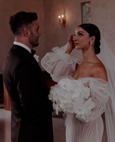 a man in a tuxedo standing next to a woman in a wedding dress