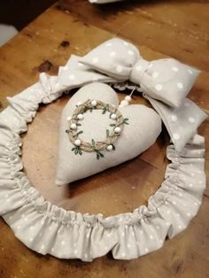 a white heart shaped pillow with a bow on it's head and some bows around the neck