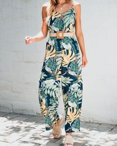 This Tropical Printed Jumpsuit is the perfect addition to take with you on vacation! It features an eye-catching tropical print design, an elastic back waist, and a sleeveless cami-style top for a breezy and relaxed feel! It also comes with a woven belt to cinch the waist and create a flattering silhouette. Style it with sandals and a floppy hat for a trendy beach look; or dress it up with wedges and statement earrings for a stylish evening ensemble. Summer Tropical Print Jumpsuits For Day Out, Summer Tropical Print Jumpsuits And Rompers For Day Out, Sleeveless Floral Print Jumpsuits And Rompers For Beach, Spring Tropical Print Jumpsuit For Day Out, Spring Tropical Print Jumpsuits And Rompers For Day Out, Spring Day Out Tropical Print Jumpsuit, Sleeveless Tropical Print Jumpsuits For Spring, Tropical Print Jumpsuits For Beach Season, Summer Vacation Tropical Print Jumpsuits And Rompers