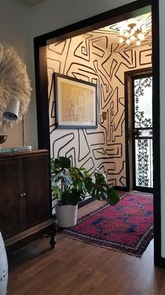 a living room with a rug, potted plant and large mirror on the wall