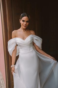 a woman in a white dress is posing for the camera