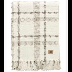 a white and brown plaid blanket with fringes